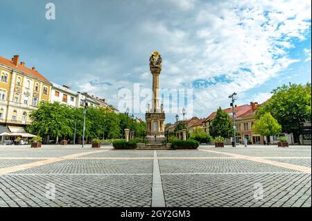 SZOMBATHELY, UNGHERIA - 15 AGOSTO 2021: Vista sulla Statua della Santissima Trinità o Szentharomsag szobor sulla piazza principale o Fo Square e la gente Foto Stock