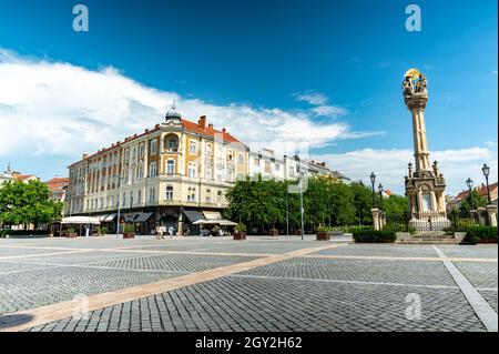 SZOMBATHELY, UNGHERIA - 15 AGOSTO 2021: Vista sulla Statua della Santissima Trinità o Szentharomsag szobor sulla piazza principale o Fo Square e la gente Foto Stock