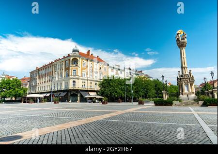 SZOMBATHELY, UNGHERIA - 15 AGOSTO 2021: Vista sulla Statua della Santissima Trinità o Szentharomsag szobor sulla piazza principale o Fo Square e la gente Foto Stock