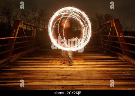 Luce bianca sfumata su un ponte di metallo di notte Foto Stock