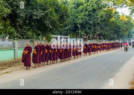 BAGAN, MYANMAR - 8 DICEMBRE 2016: File di monaci buddisti che raccolgono le loro elemosine quotidiane. Foto Stock