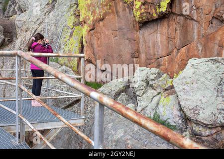 Bambina che scatta foto al rifugio di roccia di San Blas con dipinti preistorici. Alburquerque, Badajoz, Extremadura, Spagna Foto Stock