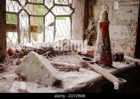 Oggetti ricoperti di polvere su un davanzale in un edificio abbandonato e disabitato. Foto Stock