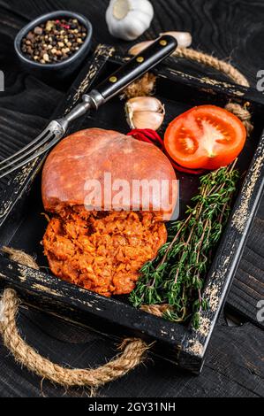 Mallorcan Sobrassada salumi di carne di maiale in un vassoio di legno sfondo di legno nero. Vista dall'alto Foto Stock