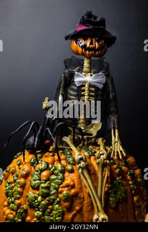 Arredamento per la vacanza di Halloween con un ghoul testa di zucca e crociera vedova nera Foto Stock