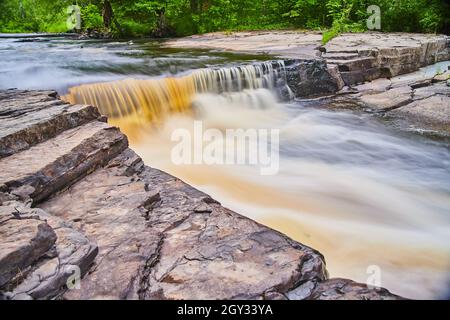 Livelli di rocce nella gola accanto alla piccola cascata Foto Stock