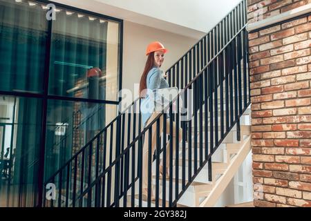 Donna su scale con notebook che guarda indietro Foto Stock