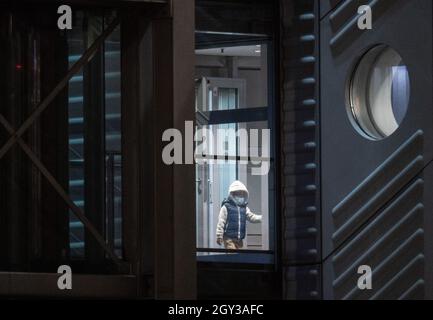 07 ottobre 2021, Hessen, Francoforte sul meno: Un giovane ragazzo entra nella zona della polizia federale all'aeroporto di Francoforte da un aereo charter. In un'azione inizialmente tenuta segreta, il governo tedesco, in collaborazione con l'esercito statunitense, aveva preso un totale di otto sostenitori tedeschi della milizia terrorista "Stato islamico" (IS) e i loro 23 bambini da un campo di detenzione in Siria nell'ambito di un'operazione umanitaria. Le donne sono state portate in Germania via Kuwait su un aereo charter, dove quasi tutte sono state immediatamente tenute in custodia. Foto: Boris Roessler/dpa Foto Stock