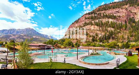 Maestose sorgenti termali nella piccola cittadina di Ouray nascosto contro le scogliere di montagna Foto Stock