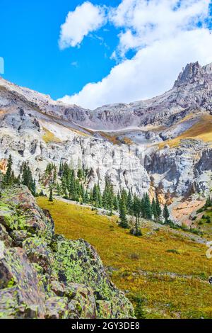 Bella catena montuosa in Colorado con rocce ricoperte di lichen e cime grigie di montagna contro cielo blu e nuvole Foto Stock