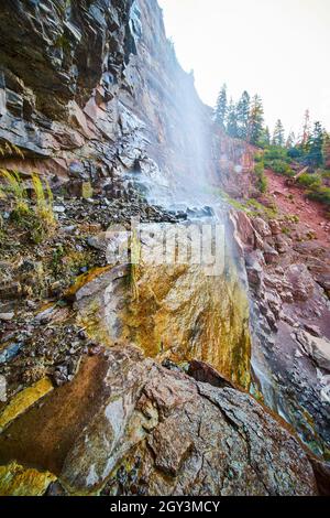 Vista dal lato dell'alta cascata che si schiantano su colorate scogliere di roccia Foto Stock