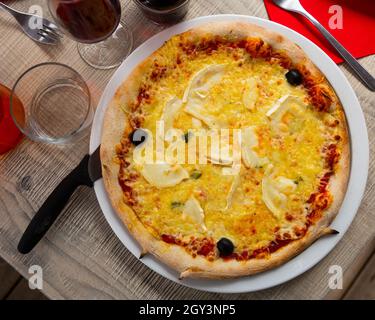 Pizza con vari formaggi, salsa di pomodoro e olive Foto Stock