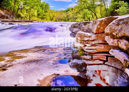Cascate vibranti vicino alla ruvida superficie rocciosa Foto Stock