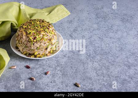 Halva con pistacchi sulla parte superiore, pochi dadi sparsi, tovagliolo di lino verde e grande spazio di copia. Dolci tradizionali mediorientali. Ebraico, turco, arabo Foto Stock