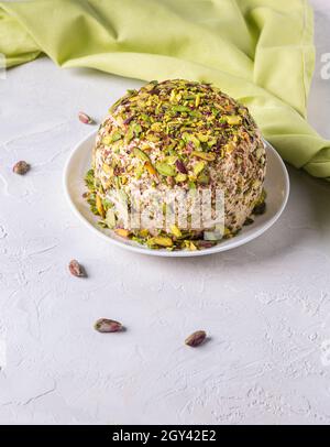 Halva al sesamo con pistacchi sulla parte superiore, pochi dadi sparsi, tovagliolo di lino verde. La delizia turca. Dolci tradizionali mediorientali. Ebraico, turco, arabo Foto Stock