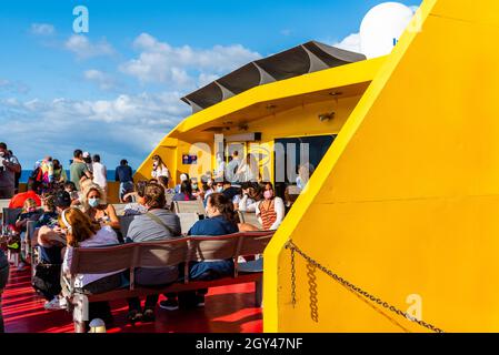 Los Cristianos, Spagna - 9 agosto 2021: Passeggeri che indossano maschere per il viso durante la pandemia del covid-19 sul ponte esterno del traghetto. Tenerife, Isole Canarie Foto Stock