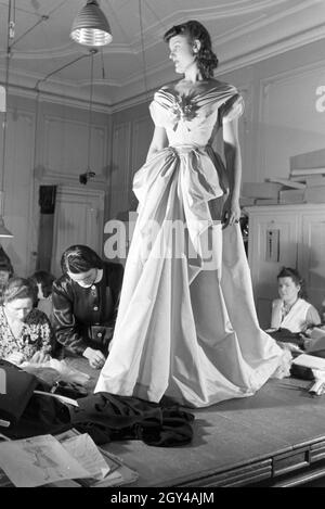 Ein Model und Schneiderinnen bei der Anprobe eines Kleides von Modeschöpferin Annemaria Geise; Deutschland ca. 1939. Un modello e sartors provando un abito di moda designer Annemaria Geise; Germania ca. 1939. Foto Stock