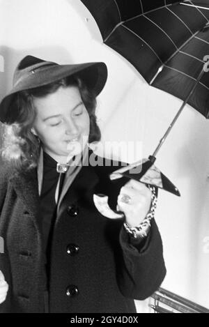 Ein Besucherin der Wiener Modewoche, im Haus der modo ' Palais Lobkowitz', bei einer Päsentation von Regenschirmen, Deutschland 1940er Jahre. Un visitatore della Vienna fashion week, nella casa di moda ' Palais Lobkowitz', a una presentazione di ombrelli, Germania 1940s. Foto Stock