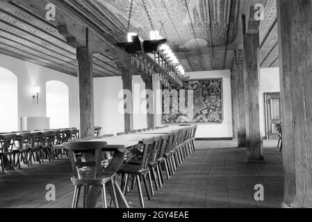 Ansicht eines Saals mit langer Tafel, Kronleuchter und Dekorationen / Reichsadler / Adler Motiv auf der Holzdecke und Teppich / Bild an der Wand, Deutschland 1930er Jahre. Vista di una sala con un lungo tavolo, lampadario e decorazioni / Imperial Eagle / eagle movente sul soffitto in legno e tappezzeria / quadro appeso alla parete, Germania 1930s. Foto Stock