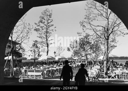 Ansicht der gut besuchten Sonnenterrasse eines cafés am Chiemsee, Deutschland 1930 jahre. Vista sulla terrazza soleggiata di una caffetteria del Chiemsee, Germania anni trenta. Foto Stock