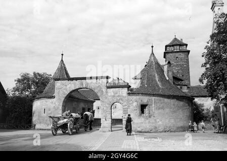 Eine Pferdekutsche beladene fährt durch das Burgtor, eines der ältesten Bauwerke in Rothenburg ob der Tauber, Deutschland 1930er Jahre. Caricata una carrozza trainata da cavalli è la guida attraverso il cancello di castello, uno dei più antichi edifici di Rothenburg ob der Tauber, Germania 1930s. Foto Stock