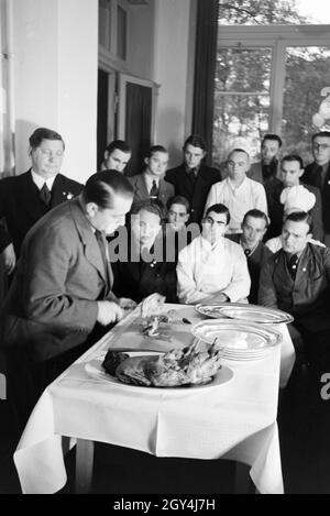 Bei einer Veranstaltung der Reichskochschule erklärt ein Meisterkoch den Lehrlingen das Richtige Filetieren, Deutschland 1930er Jahre. Un master chef è presentare il modo corretto di sfilettatura ai partecipanti nel corso di un seminario della Reichskochschule, Germania 1930s. Foto Stock