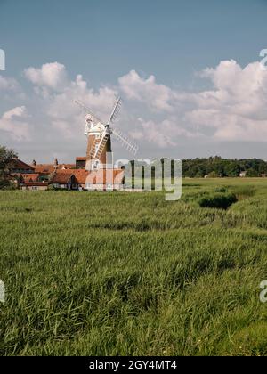 Guardando oltre i letti di canna di Cley Marshes al 18th c Cley Windmill / Towermill, North Norfolk Heritage Coast villaggio di Cley accanto al mare, Inghilterra Foto Stock