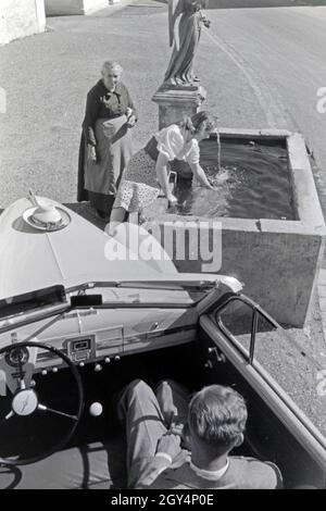 Die österreichische Schauspielerin Gusti Wolf erfrischt sich un einem Brunnen bei Ferien auf dem Lande, Deutschland 1930er Jahre. Attrice austriaca Gusti Wolf rinfrescante in corrispondenza di un pozzetto in vacanza in campagna, Germania 1930s. Foto Stock