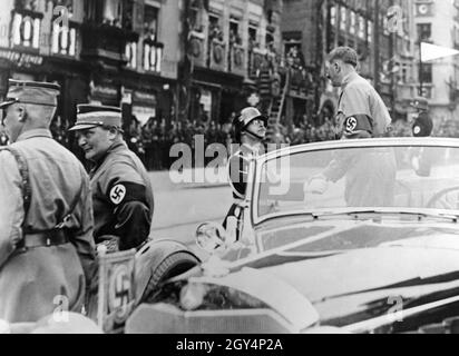 Durante il Reich Party Congress, Hitler scuote le mani con Reichsführer SS Heinrich Himmler indossando un casco da sfilata M16 da una Mercedes W150 sulla piazza principale del mercato di Norimberga, dopo che il passato di marzo dalle unità SS è stato completato. Sulla sinistra ci sono Hermann Göring in divisa di partito e Viktor Lutze. [traduzione automatizzata] Foto Stock