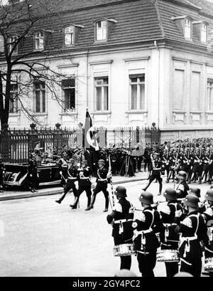 Adolf Hitler in piedi in una Mercedes W 150 convertibile, di fronte alla quale Heinrich Himmler (a sinistra) e il comandante della SS Leibstandarte Adolf Hitler e Obergruppenführer Sepp Dietrich sono anche in piedi, saluta le unità SS della Leibstandarte marciando passato con il saluto Hitler. [traduzione automatizzata] Foto Stock