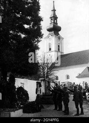 Di fronte alla tomba dei genitori di Adolf Hitler, Klara e Alois, alcuni membri del Wehrmacht salutano con il saluto di Hitler. [traduzione automatizzata] Foto Stock