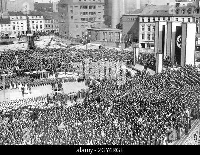 'Il 5 maggio 1934, la pietra angolare fu posata per la casa sul Werderscher Markt, che servì come estensione alla Reichsbank. Una folla di persone che salutano Hitler partecipa all'evento, comprese sezioni di organizzazioni naziste come la gioventù Hitler e il Bund Deutscher Mädel (a sinistra nella foto). Il 'Deutschlandlied' è in corso di riproduzione. Sono state erette due piattaforme rotonde e rialzate, specialmente per la stampa di quadri e film. Adolf Hitler e Hjalmar Schacht erano presenti alla cerimonia. [traduzione automatizzata]' Foto Stock