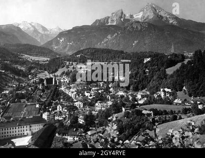 Vista della città di Berchtesgaden dal Lockstein con il Castello reale (in basso a sinistra), l'Hirschenhaus sulla piazza del mercato (accanto ad esso a destra) e la Chiesa francescana. In questa fotografia, scattata nell'estate del 1928, la catena alpina si vede sullo sfondo (da sinistra a destra): Funtenseetauern, Schönfeldspitze, Watzmann e Grünstein (direttamente di fronte). [traduzione automatizzata] Foto Stock