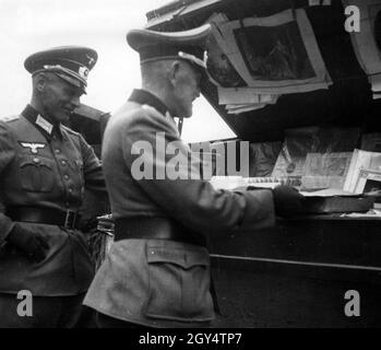 Due ufficiali della Wehrmacht tedesca in un bookstall di strada a Parigi occupata. [traduzione automatizzata] Foto Stock
