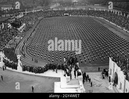 'La fotografia del 1935 mostra uno dei numerosi eventi sportivi che hanno avuto luogo per ''allenamento fisico'' in Italia fascista. Qui, le ragazze dell'ONB stanno facendo ginnastica di fronte agli stand impaccati nel Marble Stadium di Roma. [traduzione automatizzata]' Foto Stock