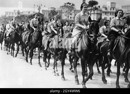 A Roma, il 26 o il 27 maggio 1939, si è svolta una grande sfilata con decine di migliaia di partecipanti provenienti da organizzazioni femminili fasciste di tutte le regioni d'Italia prima di Benito Mussolini. La foto mostra una sezione equestre femminile della Littoria (ora Latina). Le giovani donne sono probabilmente membri della giovane fascista, un sottogruppo dell'Opera Nazionale Balilla. [traduzione automatizzata] Foto Stock