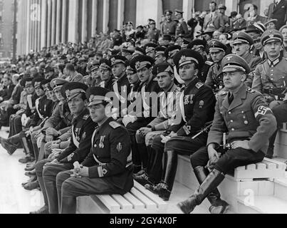 "Il 1° maggio 1937, si è svolto a Berlino-Mitte il grande raduno per la "'festa nazionale del popolo tedesco'". Su una tribuna del Lustgarten, gli ufficiali Balilla italiani (uniformi nere) dell'entourage del leader giovanile Renato Ricci hanno assistito alla sfilata accanto agli ufficiali HJ. All'estrema destra si trova un capo di zona della Gioventù Hitler. [traduzione automatizzata]' Foto Stock