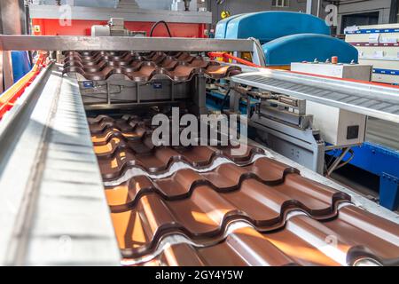 Tegole marroni in lamiera d'acciaio zincato e verniciato in lamiera in fabbrica. Foto Stock