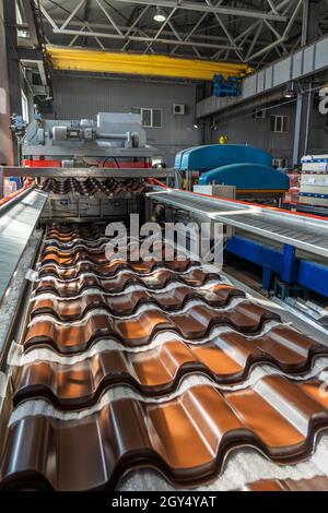 Tegole marroni in lamiera d'acciaio zincato e verniciato in lamiera in fabbrica. Foto Stock