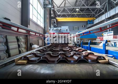 Tegole marroni in lamiera d'acciaio zincato e verniciato in lamiera in fabbrica. Foto Stock