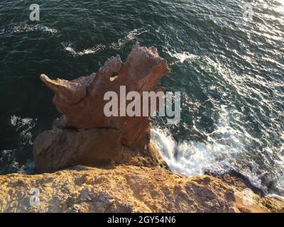 La testa del drago sorge dall'acqua - la roccia o la formazione di lava con la forma di un grande animale. Popolare destinazione di viaggio formazione di roccia vulcanica in Foto Stock