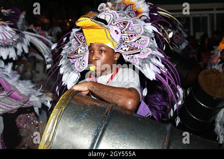 Gente, vestita in costumi, battendo i tamburi mentre celebra Junkanoo nelle strade delle Bahamas Foto Stock