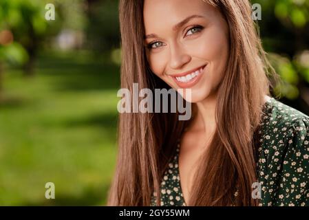 Foto di bella positiva tranquilla signora relax vacanza indossare verde vestito parco naturale giardino all'aperto Foto Stock