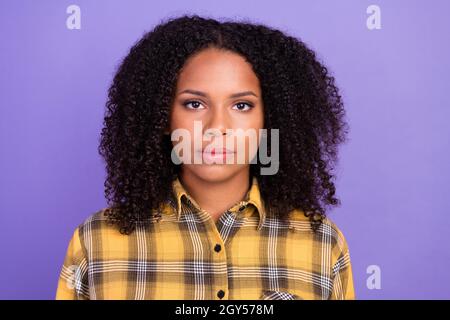 Foto di grave giovane pelle scura donna indossare camicia a quadri casual calmo viso isolato su sfondo di colore viola Foto Stock