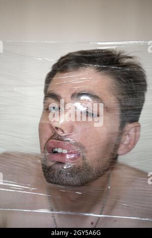 Testa di uomo in contenitore di cibo. Il volto di un uomo in una confezione di cibo. Foto Stock