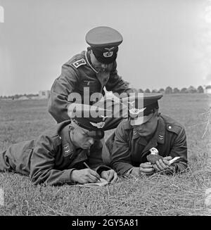 Zwei Rekruten der Luftwaffe der Wehrmacht mit ihrem Ausbilder und einer Brieftaube in der Heeres-Brieftauben-Anstalt, Berlin Spandau 1930er Jahre. Due reclute della Luftwaffe tedesca con la loro punta seargant ed un carrier pigeon, Berlin Spandau 1930s. Foto Stock