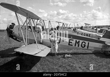 Rekruten der Luftwaffe der Wehrmacht auf dem Flugfeld der Flieger Ausbildungsstelle Schönwalde un ihrem Ausbildungsflugzeug Bücker bü 131 Jungmann, Deutschland 1930er Jahre. Reclute della Luftwaffe tedesca all'aeroporto del Flieger Ausbildungsstelle Schoenwalde ed i loro piani di formazione, Germania 1930s. Foto Stock