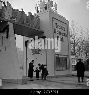 Ein kleiner Junge mit seinen Eltern am Eingang zum Berliner Weihnachtsmarkt, Deutschland 1930er Jahre. Un ragazzino con i suoi genitori all'ingresso della Berlino Mercatini di Natale, Germania 1930s. Foto Stock