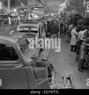 Karosserien schweben an den Arbeitern in den Ford Werken in Köln Niehl vorüber, Deutschland 1930er Jahre. Telaio venite a fianco dei lavoratori presso la fabbrica Ford a Colonia, Germania 1930s. Foto Stock