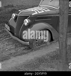 Ein Ford Eifel steckt bei einer Autorallye im Schlamm fest, Deutschland 1930er Jahre. Un modello Ford Eifel inceppato nel fango ad un auto rallye, Germania 1930s. Foto Stock